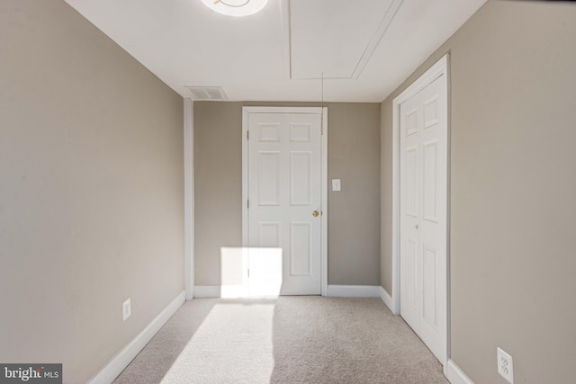 unfurnished bedroom featuring attic access, carpet, visible vents, and baseboards