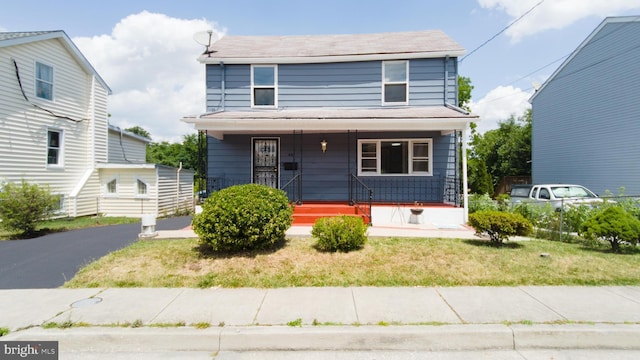 view of front of house with covered porch and a front lawn