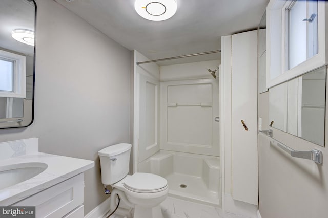 bathroom featuring a stall shower, vanity, and toilet