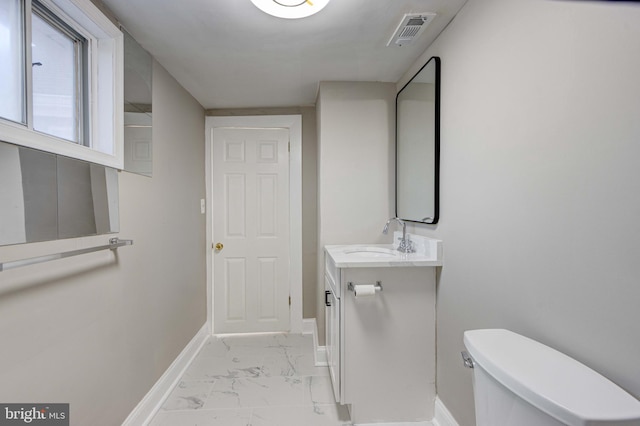 half bathroom featuring marble finish floor, visible vents, toilet, vanity, and baseboards