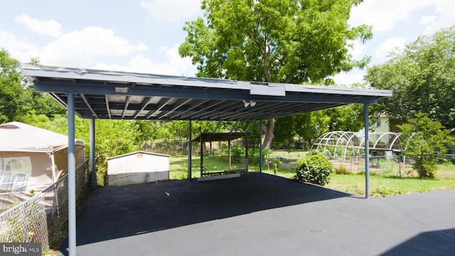 view of car parking featuring a carport and fence