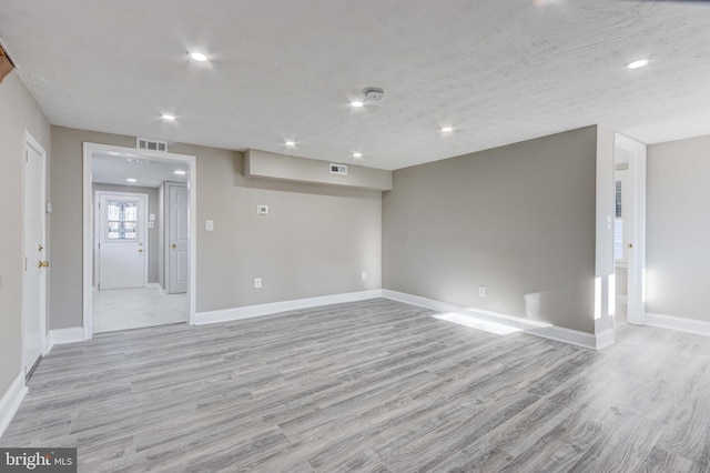 empty room with baseboards, recessed lighting, visible vents, and light wood-style floors