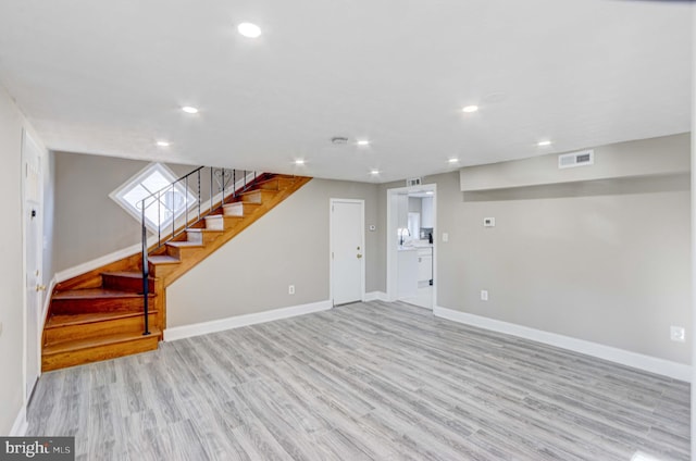 basement with light wood-style flooring, recessed lighting, visible vents, baseboards, and stairway