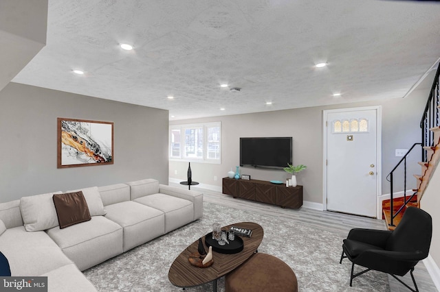 living area featuring recessed lighting, stairs, a textured ceiling, and wood finished floors