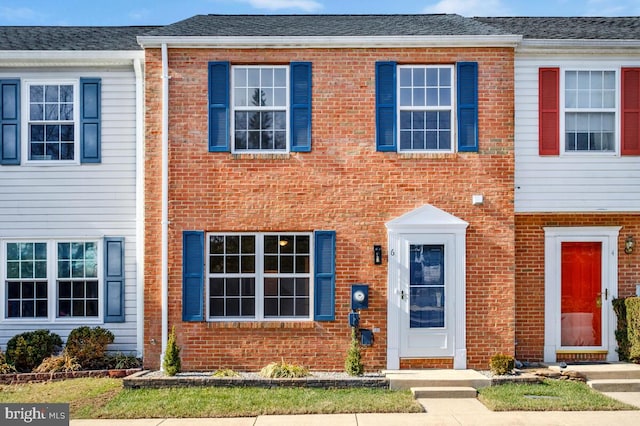 townhome / multi-family property with brick siding and roof with shingles