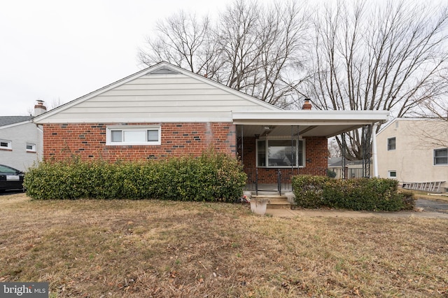 bungalow featuring a chimney, brick siding, a front lawn, and a porch