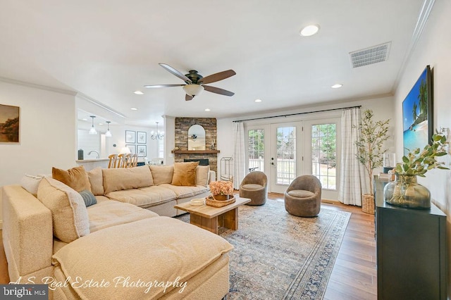 living room featuring crown molding, recessed lighting, visible vents, a ceiling fan, and wood finished floors