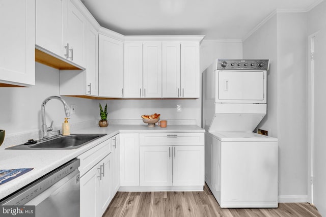 interior space with stacked washer and dryer, white cabinetry, dishwasher, and a sink