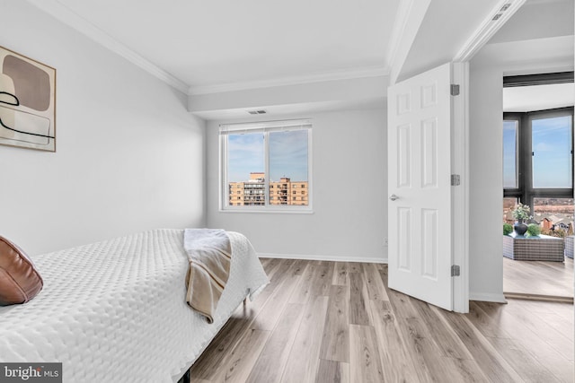 bedroom featuring ornamental molding, baseboards, and light wood finished floors