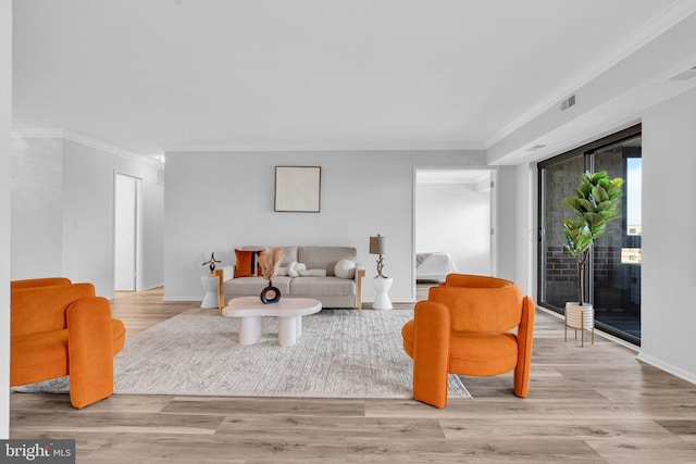 living area with ornamental molding, wood finished floors, and baseboards