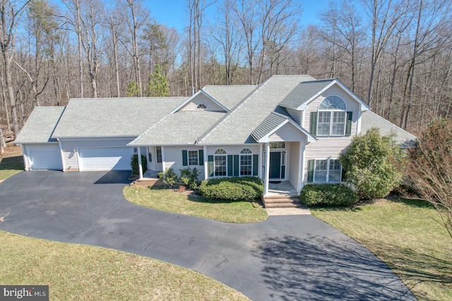 view of front of property featuring aphalt driveway, a front lawn, and an attached garage