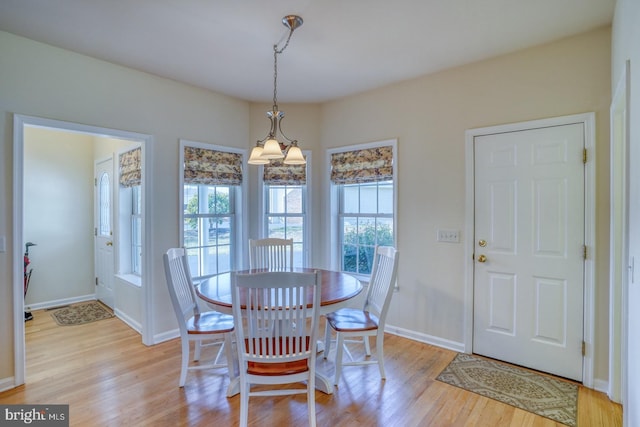 dining space with light wood-type flooring, a wealth of natural light, and baseboards