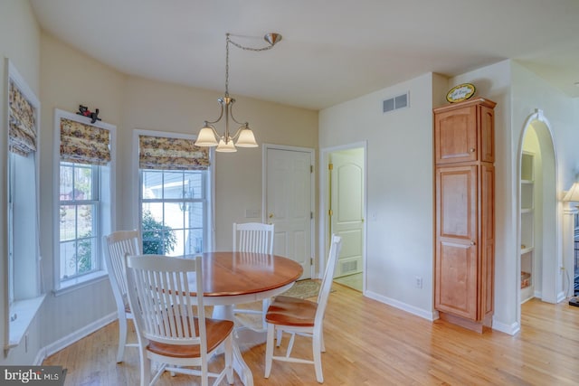 dining area with a chandelier, visible vents, light wood-style flooring, and baseboards