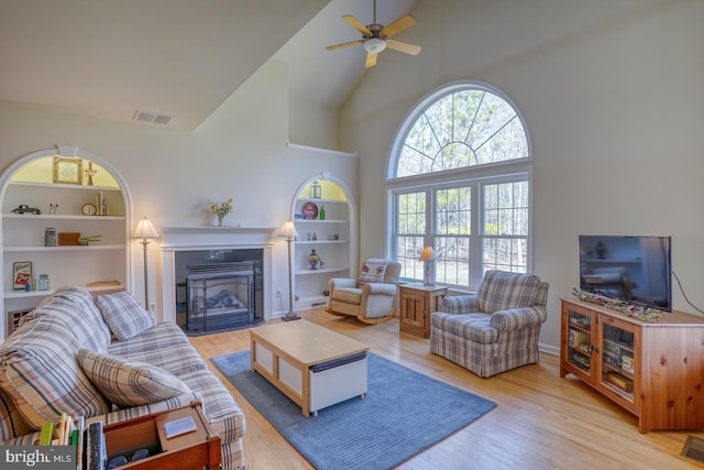 living area with built in features, visible vents, plenty of natural light, and light wood finished floors