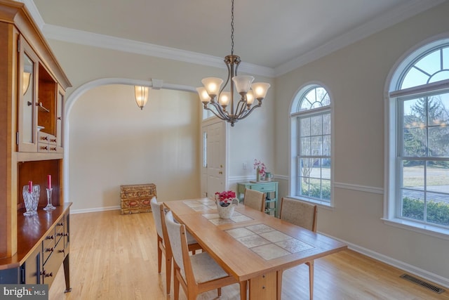 dining room with light wood-style floors, visible vents, plenty of natural light, and crown molding