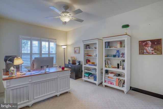 office space with light carpet, ceiling fan, and baseboards