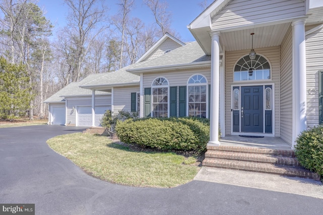 property entrance featuring roof with shingles