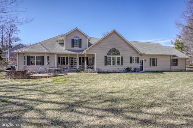 back of property with central AC, a lawn, a patio, and roof with shingles