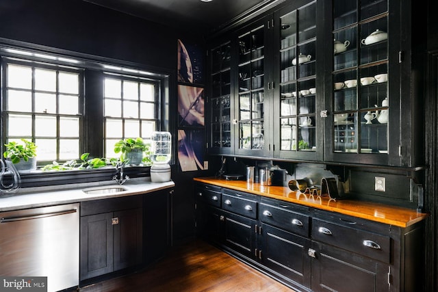 bar with dark wood-style flooring, a sink, and stainless steel dishwasher