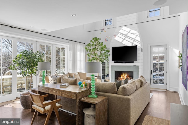 living room with a warm lit fireplace and wood finished floors