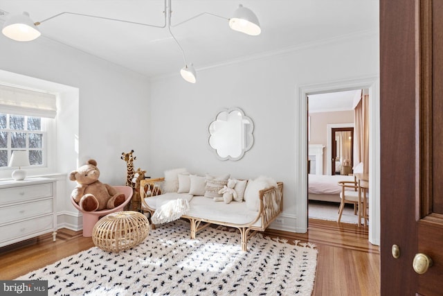 sitting room with crown molding and wood finished floors