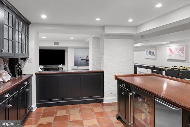 kitchen featuring wine cooler, dark countertops, glass insert cabinets, and recessed lighting