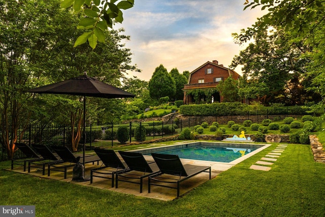 pool at dusk with a patio area, fence, a fenced in pool, and a yard