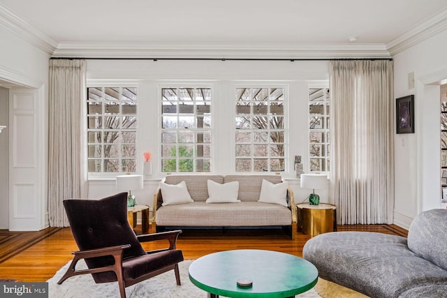 living area with ornamental molding and wood finished floors