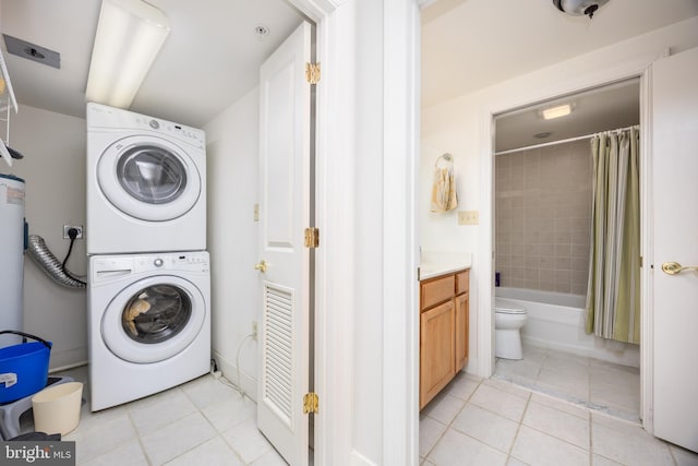 laundry area featuring light tile patterned flooring, laundry area, and stacked washer and dryer