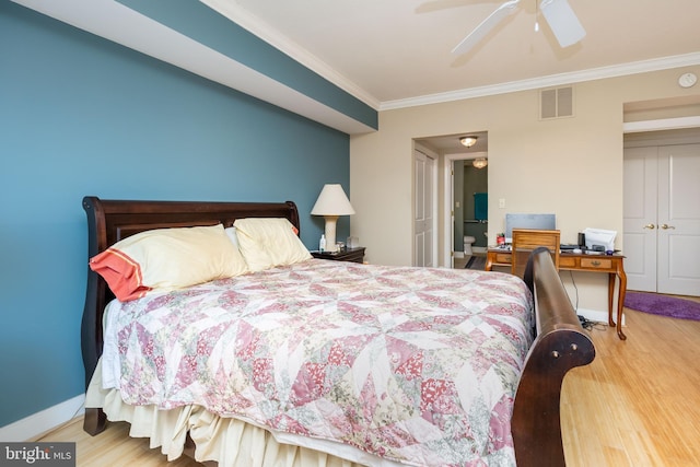 bedroom featuring visible vents, ceiling fan, baseboards, ornamental molding, and wood finished floors