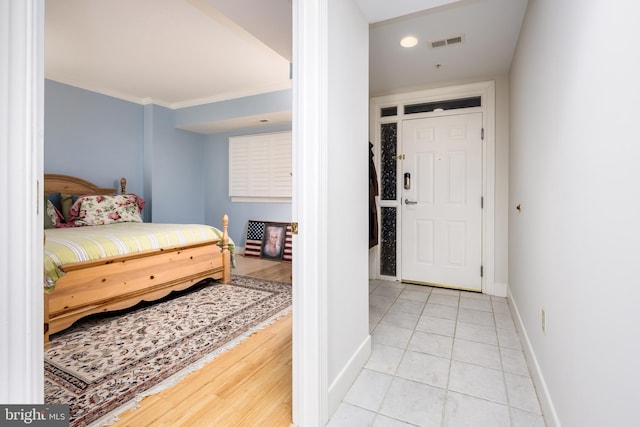 tiled bedroom featuring visible vents, crown molding, and baseboards