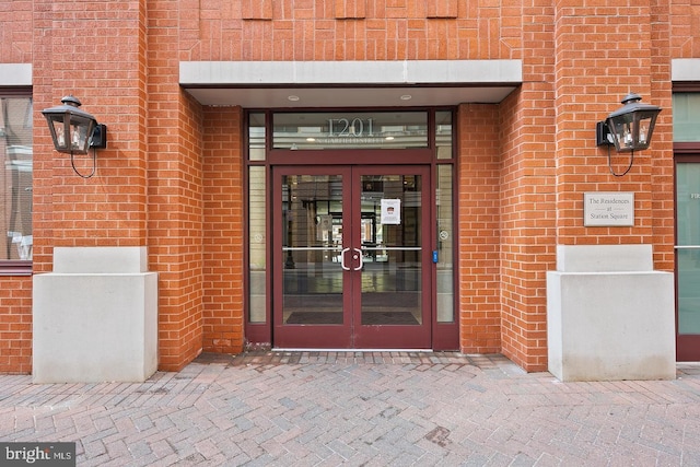 property entrance featuring french doors and brick siding