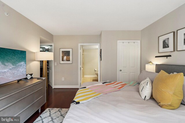 bedroom featuring ensuite bath, wood finished floors, and baseboards