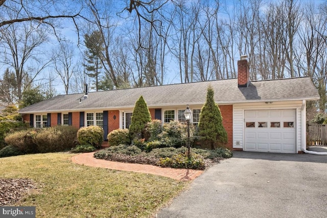 ranch-style house with a garage, brick siding, driveway, a chimney, and a front yard