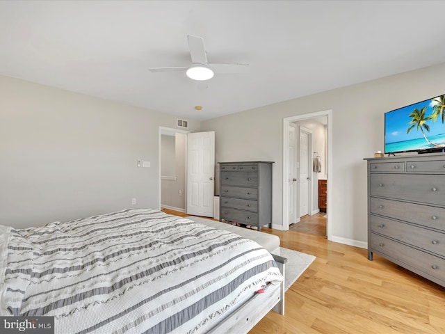 bedroom featuring light wood finished floors, baseboards, visible vents, and ceiling fan