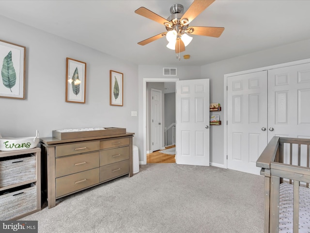 bedroom featuring a closet, light colored carpet, visible vents, ceiling fan, and baseboards