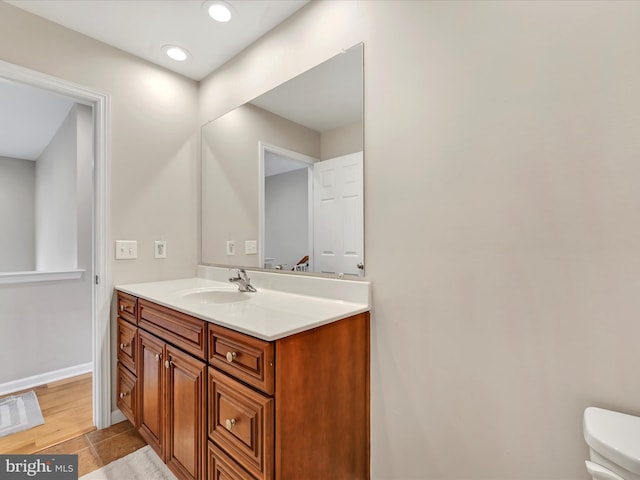 bathroom with recessed lighting, toilet, vanity, baseboards, and tile patterned floors