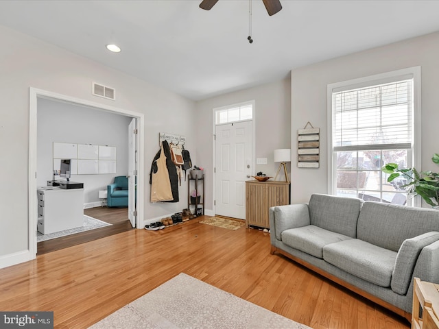 foyer with a wealth of natural light, wood finished floors, visible vents, and baseboards