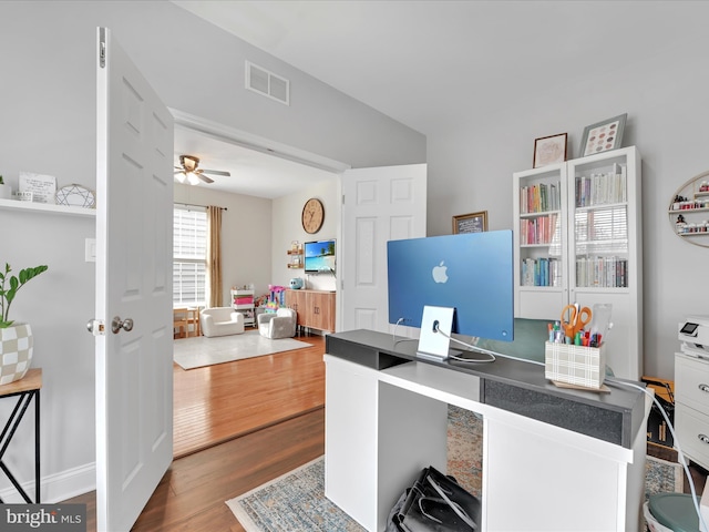 home office with a ceiling fan, visible vents, and wood finished floors