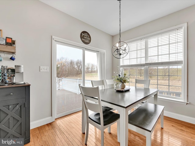 dining area featuring baseboards, a chandelier, and light wood-style floors