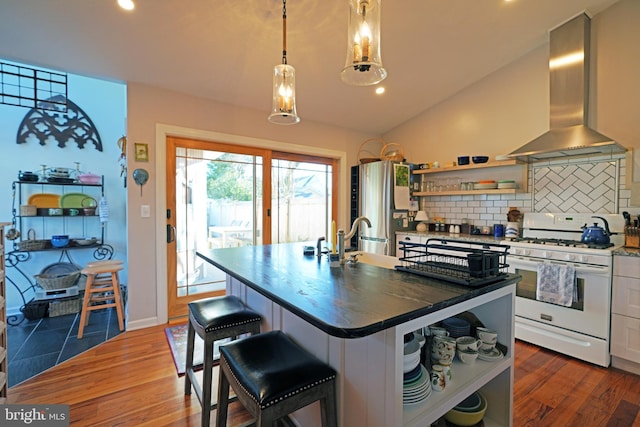 kitchen featuring white gas range oven, freestanding refrigerator, vaulted ceiling, wall chimney range hood, and open shelves