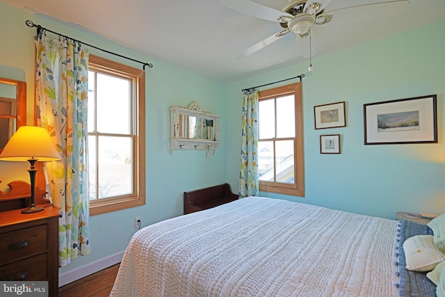 bedroom with ceiling fan, baseboards, and wood finished floors