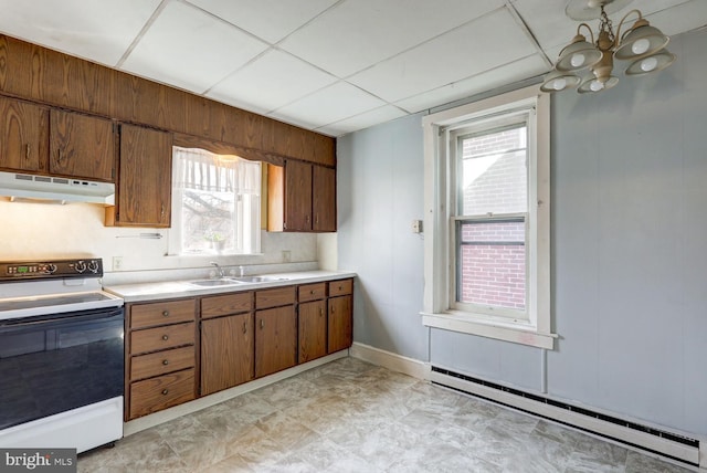 kitchen featuring a baseboard radiator, a sink, range with electric cooktop, a drop ceiling, and under cabinet range hood