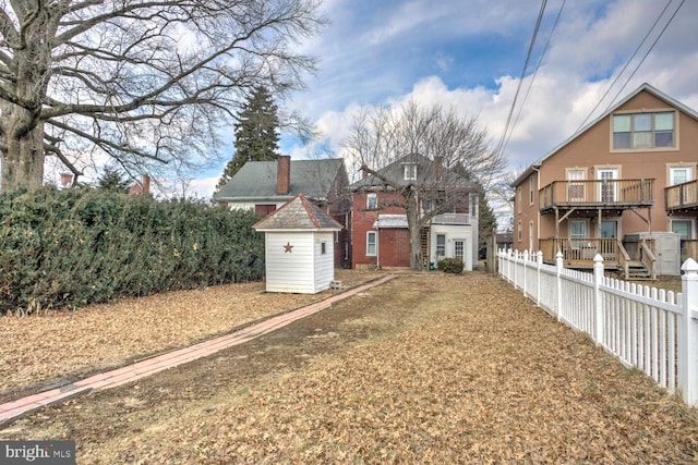 view of yard featuring an outbuilding, fence, and a shed