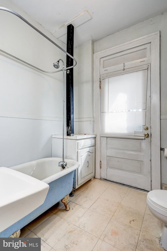 bathroom with toilet, a soaking tub, tile patterned flooring, and a shower