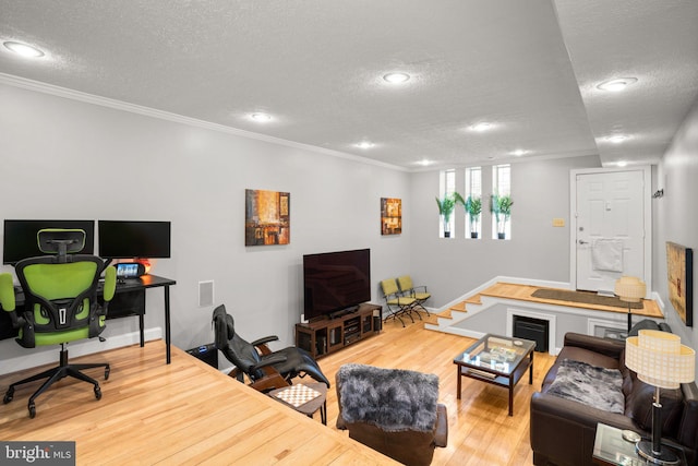 living area with recessed lighting, a textured ceiling, crown molding, and wood finished floors