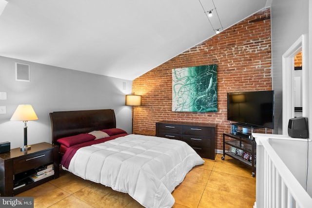 bedroom featuring light tile patterned floors, visible vents, brick wall, and vaulted ceiling