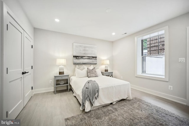 bedroom featuring light wood-style floors, visible vents, baseboards, and recessed lighting