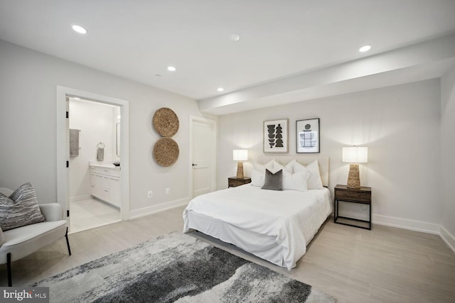 bedroom featuring recessed lighting, light wood finished floors, baseboards, and ensuite bathroom