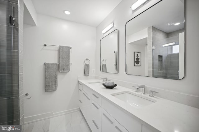 bathroom with a stall shower, marble finish floor, a sink, and baseboards